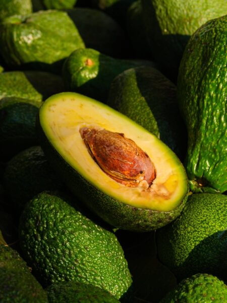 Close-up of a ripe avocado halved to reveal its seed and green flesh, emphasizing freshness and health.