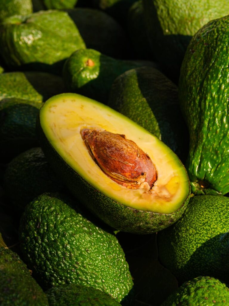 Close-up of a ripe avocado halved to reveal its seed and green flesh, emphasizing freshness and health.